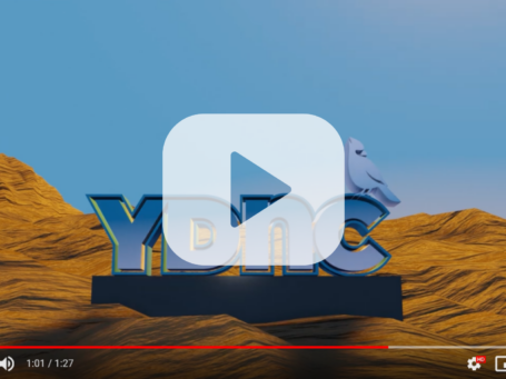 A screenshot of a YouTube video showing the YDNC Logo on a pedestal in a rocky landscape.
