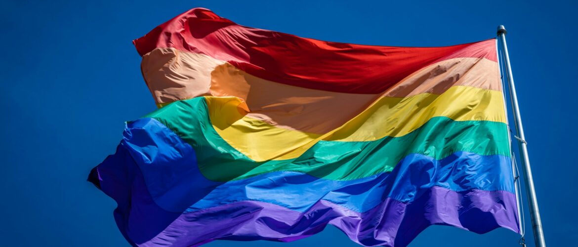 Close up of the enormous 20x30 foot rainbow flag flying proud over Harvey Milk Plaza in the Castro district of San Francisco California